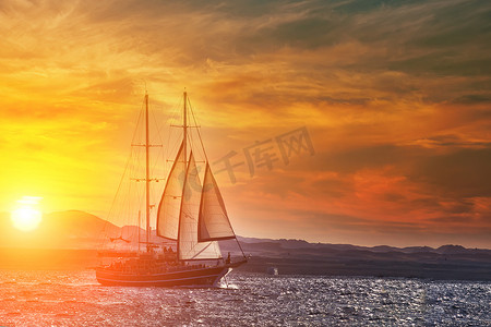 夕阳下，在宁静的海洋上古老的古船。平静的波浪反射，日落。复制空间