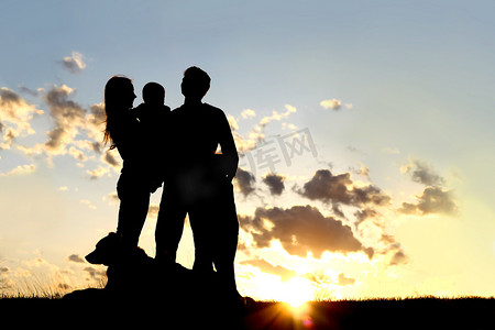 外边摄影照片_快乐的年轻家庭和狗剪影，日落时分