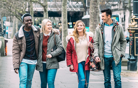 多来a梦摄影照片_在伦敦市中心散步的千百年来的多种族朋友- -下一代不同文化的友谊概念- -穿着冬季时尚服饰在一起玩乐- -柔和的蓝色过滤器
