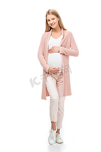全长孕妇在粉红色的羊毛衫触摸腹部隔离在白色