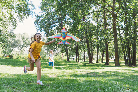 可爱的快乐孩子们玩着五颜六色的风筝在公园里 