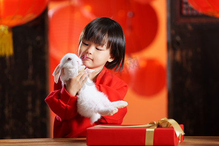 清新可爱动物摄影照片_可爱的小男孩收到新年礼物小兔子