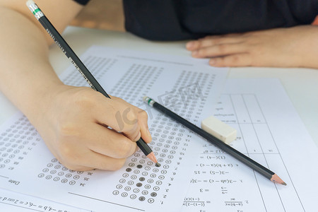 学生们手握铅笔，在答题单和数学试卷上选择写作选项。通过考试的学生。学校考试