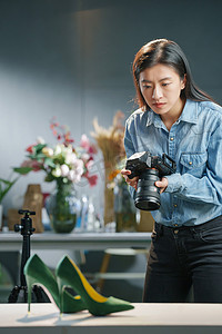 公司印章管理摄影照片_在工作室里拍照的青年女摄影师