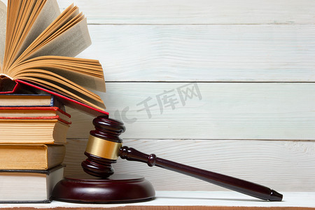 法律书籍与木槌木法官在法庭或法律的执法办公室的桌子上.