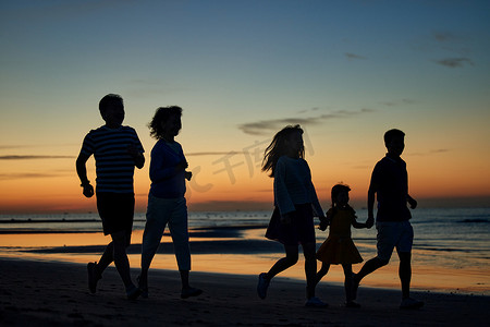 奔跑的儿童剪影摄影照片_在海边度假的快乐家庭