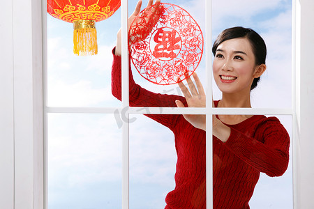 中国剪纸云摄影照片_青年女人新年贴窗花