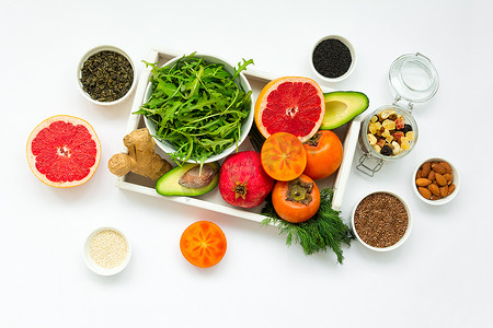 木托盘中的健康食品: 白色背景下的水果、蔬菜、种子和蔬菜。平躺。顶部视图