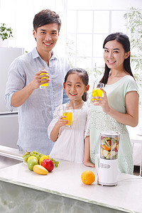 时尚水果果汁摄影照片_一家三口在厨房喝果汁