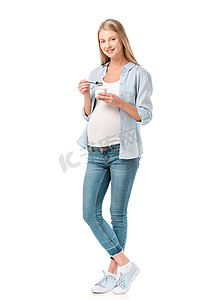 美丽的微笑怀孕的妇女持有酸奶查出的白色