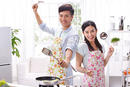 冰箱异性摄影照片_年轻夫妇在厨房做饭