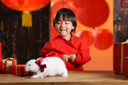 礼物元素摄影照片_可爱的小男孩收到新年礼物小兔子