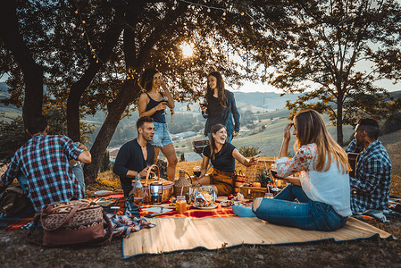 一群年轻快乐的朋友在户外野餐--人们在农村烧烤巴瓦库派对时, 一边玩得很开心, 一边庆祝