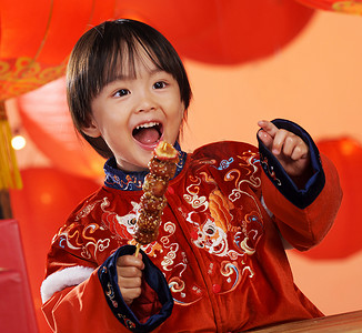 可爱的小男孩拿着糖葫芦庆新年