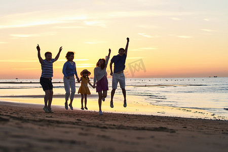 奔跑的儿童剪影摄影照片_在海边度假的快乐家庭