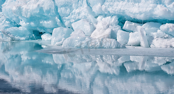 冰山一角摄影照片_蓝色咆哮者一块平静的水中倒影的冰山一角。北冰洋