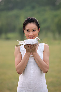 东方女人户外手捧和平鸽