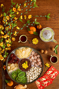 新年祝福立牌摄影照片_农历新年餐桌上配有干果坚果, 杏枝, 祝福牌的盘子