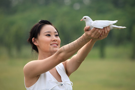 东方女人户外手捧和平鸽