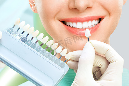 Close up portrait of Young women in dentist chair, Check and select the color of the teeth. Dentist makes the process of treatment in dental clinic office. Teeth whitenning