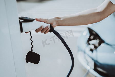 特斯拉汽车电缆插头插座。汽车充电站的概念。创新技术。新一代电动混合动力汽车插件。生态收费站。未来力量.