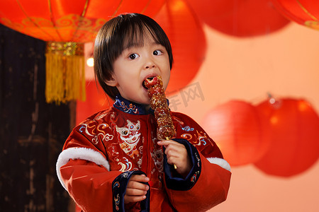 可爱的小男孩拿着糖葫芦庆新年