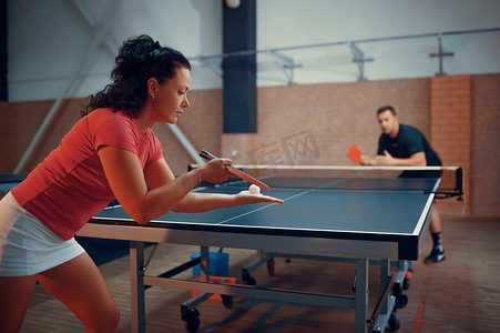 乒乓球运动员女摄影照片_乒乓球，男、女乒乓球运动员。夫妻二人在室内打乒乓球，有球拍的体育运动，积极健康的生活方式
