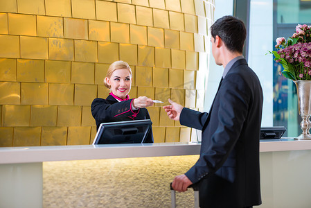 钥匙男人摄影照片_在一家酒店签入在接待或前厅部得到钥匙卡的男人