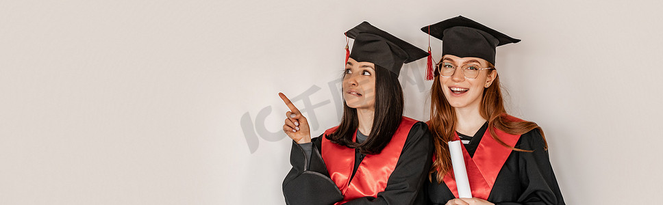 穿着毕业礼服头戴帽子的漂亮学生，手指指向快乐的同学，2021年高年级，横幅