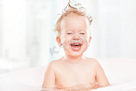 婴儿洗澡摄影照片_快乐有趣的婴儿笑和沐浴在浴
