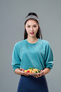 轻食沙拉图片摄影照片_端着蔬菜沙拉的青年女人