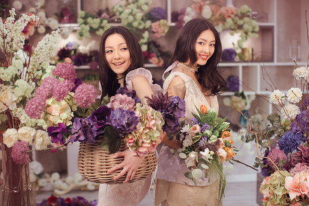 美丽的亚洲女人花匠快乐地在开着很多春花的花店里工作