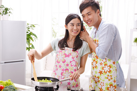 手机容器摄影照片_年轻夫妇在厨房做饭