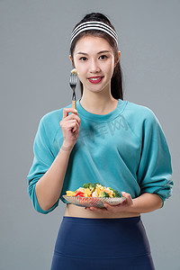 轻食沙拉图片摄影照片_吃蔬菜沙拉的青年女人