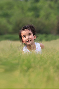 可爱的太阳表情摄影照片_东方儿童蹲在草地上