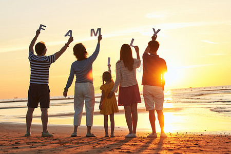 海边夕阳天空摄影照片_在海边度假的快乐家庭