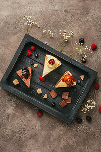 木托盘上的巧克力和浆果的美味蛋糕的顶端视图   