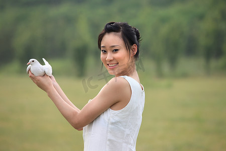 和平鸽摄影照片_东方女人户外手捧和平鸽