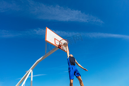 乔丹扣篮摄影照片_年轻的篮球街球员做灌篮扣篮