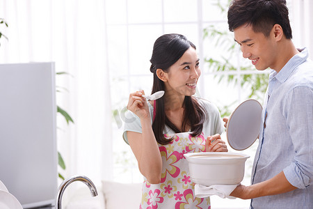 冰箱异性摄影照片_年轻夫妇在厨房做饭