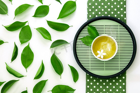 热奶茶摄影照片_热杯茶与绿叶装饰的顶部查看镜头