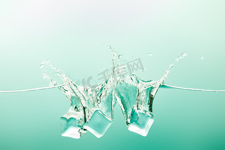 纯净水摄影照片_透明纯净水，绿色背景上飞溅和冰块