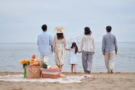 母亲背影摄影照片_快乐的一家人在海边度假