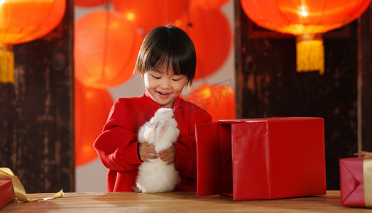 兔子新年春节摄影照片_可爱的小男孩收到新年礼物小兔子