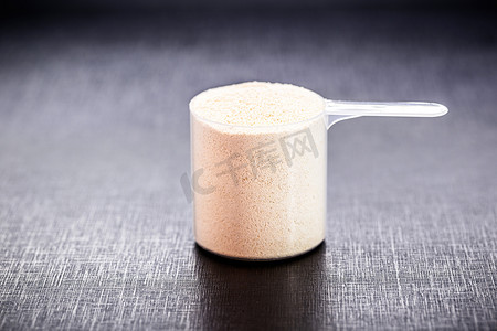 measuring spoon with casein and creatine, powdered food supplements, protein or amino acid used by athletes