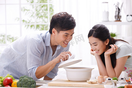 爱吃的表情摄影照片_年轻夫妇在厨房做饭