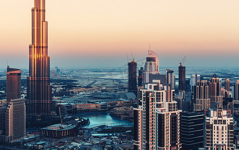 美丽的现代建筑的大城市。迪拜商业湾塔楼日落时分的风景全景。建筑背景.