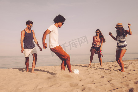 沙滩足球摄影照片_最好的朋友玩沙滩足球