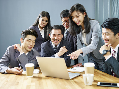 线条组成的花纹摄影照片_一支由亚洲企业高管组成的团队, 使用膝上型电脑在办公室工作, 快乐和微笑.