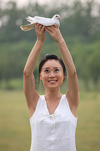 东方女人户外手捧和平鸽